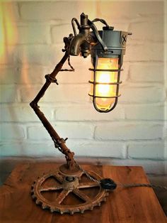 an old fashioned lamp is sitting on top of a wooden table next to a white brick wall