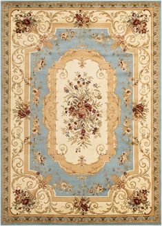 a blue and beige rug with an ornate border on the bottom, surrounded by flowers