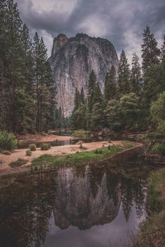 the mountain is surrounded by trees and water