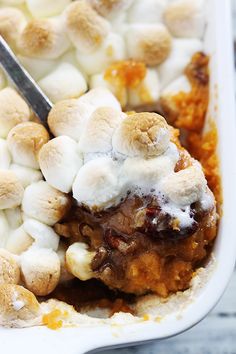 a close up of food with marshmallows on it and a spoon in it