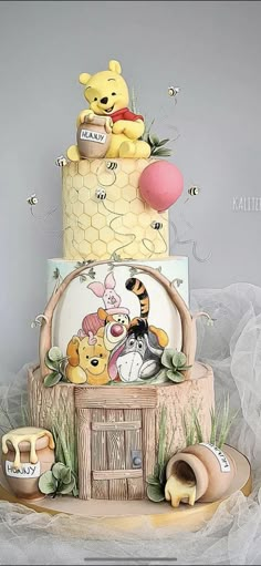 a winnie the pooh birthday cake with honeycombs and other items on it