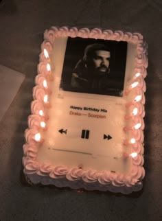 a birthday cake with an image of a man on the side and candles around it