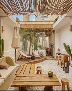 an outdoor living area with wooden tables and chairs