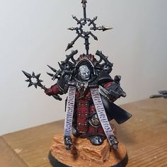 a warhammer is standing on top of a wooden table and holding two swords in his hand