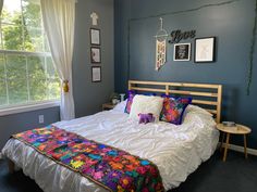 a bed in a room with blue walls and pictures on the wall