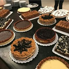 a table topped with lots of different types of cakes and pies next to each other