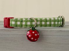 a green and white checkered dog collar with a red ladybug on it