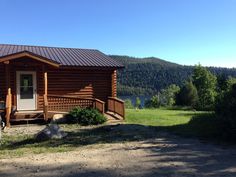 a small log cabin sits on the side of a hill