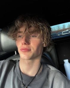 a young man sitting in the back seat of a car with his head turned to the side