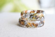 two wedding bands with different colored rocks on them sitting on a table top next to each other