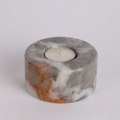 a marbled candle holder with a lit candle