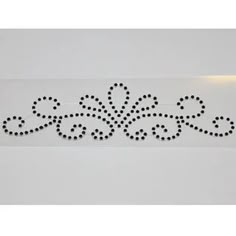 a white wall with black dots and an ornate design on it's side,