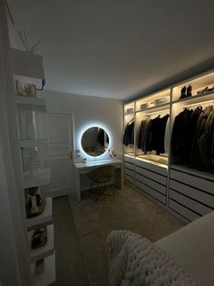 a bedroom with white walls and shelves filled with clothes