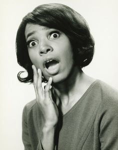 a black and white photo of a woman making a surprised face