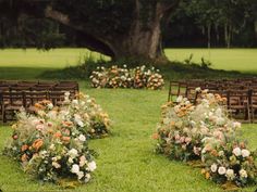 an outdoor ceremony with rows of wooden chairs and flowers on the grass in front of them