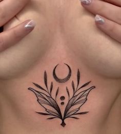 a woman's chest with an artistic tattoo on it