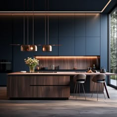 a modern kitchen with an island and bar stools next to the countertop that is illuminated by pendant lights