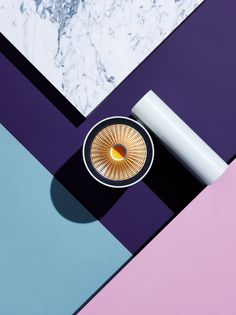 an overhead view of a table with a vase and candle on it, against a multi - colored background