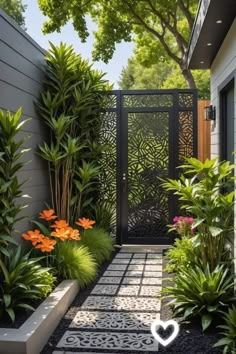 an outdoor garden with lots of plants and flowers on the side of the house,