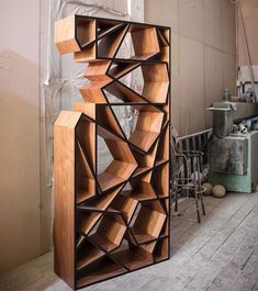 a wooden book shelf sitting in the middle of a room