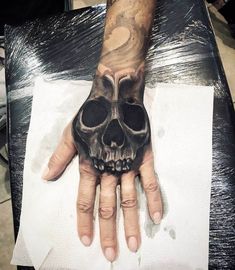 a hand with a skull tattoo on it