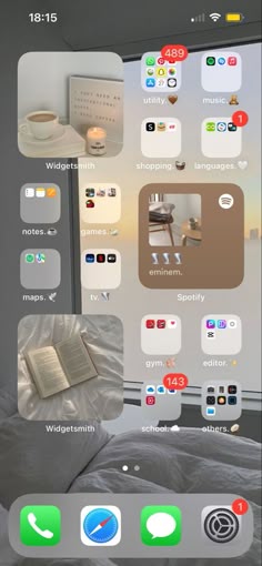 an iphone with several different icons on the screen and in front of it is a bed