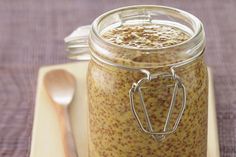 a glass jar filled with food sitting on top of a table next to a spoon