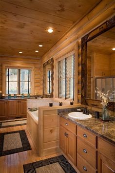 a large bathroom with wood paneling and granite counter tops, along with two sinks