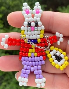 a person is holding a small beaded toy