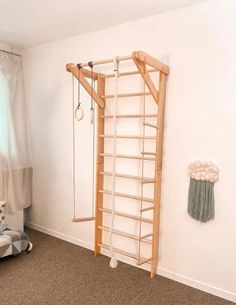 a baby's room with a ladder and teddy bear on the floor next to it