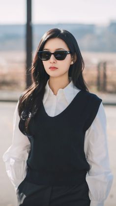 a woman wearing sunglasses and a black vest