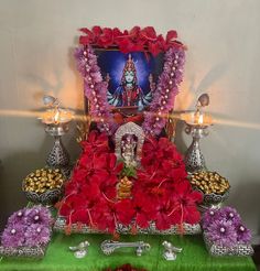 there is a shrine with flowers and candles on the table, surrounded by other decorations