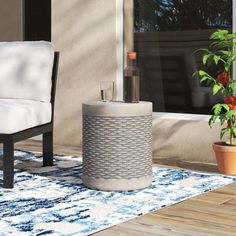 a white chair sitting on top of a wooden floor next to a potted plant