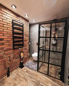 a bathroom with a brick wall and glass doors