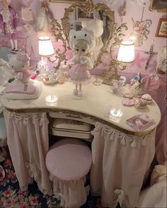 a vanity with a teddy bear on it in a room filled with pink and white furniture