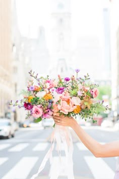 a woman holding a bouquet of flowers on the street