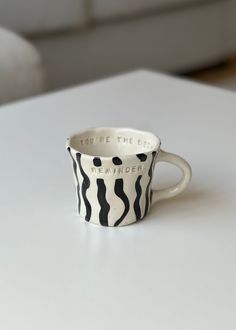 a coffee cup sitting on top of a white table