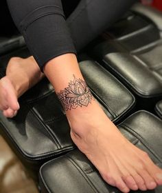 a woman's foot with a tattoo on her left arm and the other hand