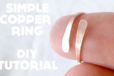 a close up of a person's finger with the words simple copper ring on it