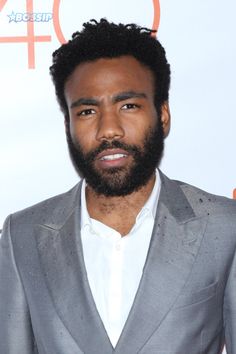 a man with a beard wearing a gray suit