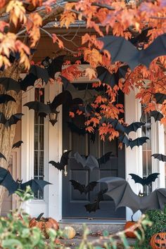 halloween decorations on the front door of a house with bats and pumpkins hanging from it