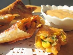 some food is laying out on a table next to a bowl and plate with dipping sauce