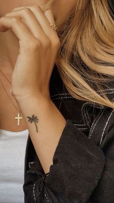 a woman with a cross tattoo on her wrist