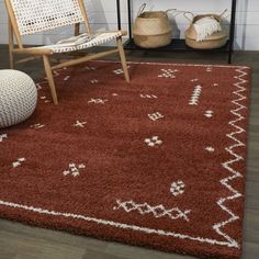 a brown rug with white designs on it and a chair in the corner next to it