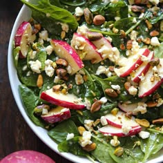 a salad with apples, cheese and nuts in a bowl