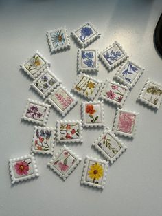 small embroidered stamps with flowers on them are sitting on a table next to a computer mouse