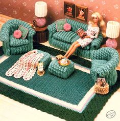 a doll is sitting on a couch in a living room with crocheted furniture