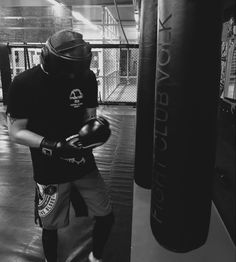 a man standing next to a punching bag