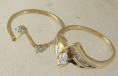 two gold wedding rings with diamond accents on each side, sitting on a white surface