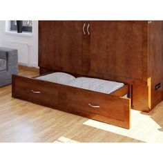 a bed with two drawers in the middle of it and a couch next to it